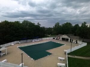 Covered swimming pool, white fence, and pool house at Woodneath Farms.