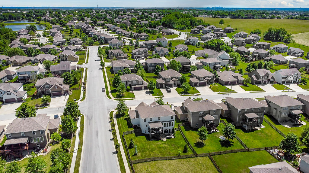 Aerial view of detached homes, streets and green space
